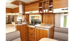 a kitchen in an rv with wooden cabinets at Mietwohnwagen Oscar Fehmarn in Fehmarn