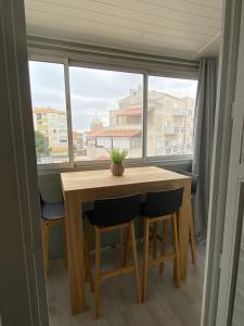 tavolo e sedie in una stanza con finestra di Superbe Apt, 250m plage du môle, clim, parking a Cap d'Agde