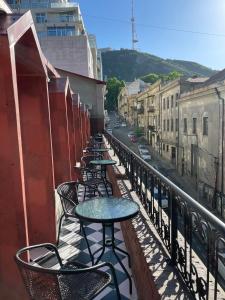 una fila de mesas y sillas en un balcón en Shota Rustaveli Aparthotel en Tiflis