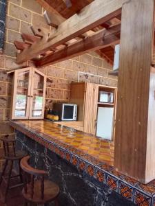 a kitchen with a bar with chairs and a microwave at Cabaña el piñon en Ezequiel Montes in Ezequiel Montes