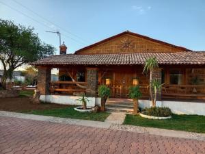 a wooden house with a porch with palm trees in front at Cabaña el piñon en Ezequiel Montes in Ezequiel Montes +24 photos