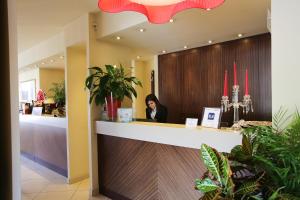 a woman is sitting at a counter in a salon at Hotel Touring in Fiorano Modenese