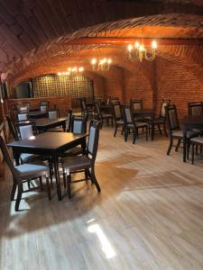 a dining room with tables and chairs and a brick wall at Pensiunea Casa Helis in Sibiu
