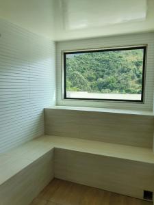 een lege kamer met een raam en een bank bij Casa Villa Constanza in Itaipava