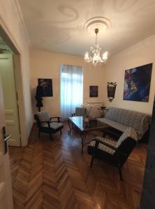 uma sala de estar com um sofá, cadeiras e uma mesa em Skorpion em Belgrado