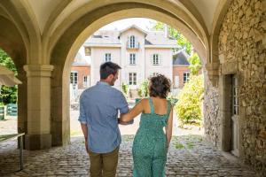 a man and woman standing in an archway looking at a house at Château de la Tourlandry in Chemillé