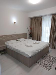 1 dormitorio con 1 cama grande con sábanas blancas en Hotel Babilon, en Bucarest