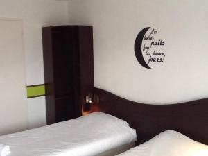 um quarto com uma cama e uma lua na parede em Couett' Hotel Rumilly em Rumilly