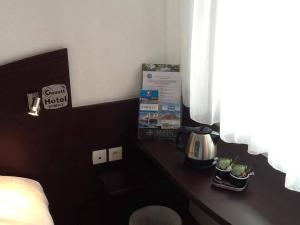Příslušenství pro přípravu čaje a kávy v ubytování Couett' Hotel Rumilly