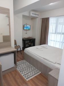 Habitación de hotel con cama grande y TV en Hotel Babilon, en Bucarest