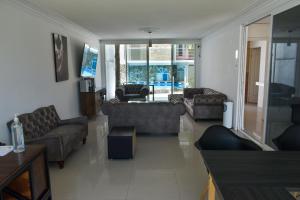 ein Wohnzimmer mit Sofas, einem Sofa und einem TV in der Unterkunft 10 VENATOR House Boutique in León