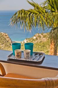 una bandeja con tres tazas y cucharas en una mesa en Mountain & Sea Villa en Kyra Panagia