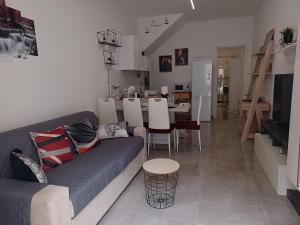 a living room with a couch and a dining room at Casa Ciuzza in Syracuse