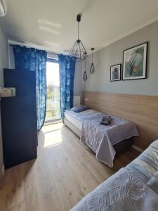 1 Schlafzimmer mit 2 Betten und einem Fenster in der Unterkunft Sailor Apartament Nadmorski 30 in Ustronie Morskie