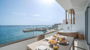 een tafel met eten erop met uitzicht op de oceaan bij Sfakia Seaside luxury Suites in Khóra Sfakíon