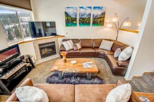 a living room with a leather couch and a fireplace at Forest Park 31E in Silverthorne