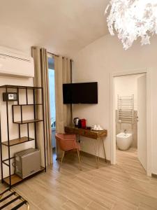 a living room with a desk and a television at Relais Roma Vaticano - METRO station Ottaviano in Rome