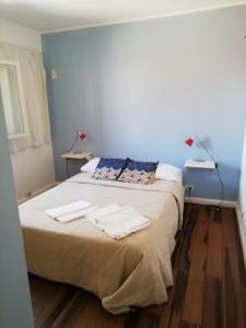 1 dormitorio con 1 cama con 2 toallas en La Casa Roja Arroyito Rio en Rosario