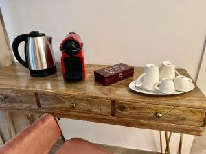 una macchinetta del caffè e tazze su un tavolo di legno di Relais Roma Vaticano - METRO station Ottaviano a Roma