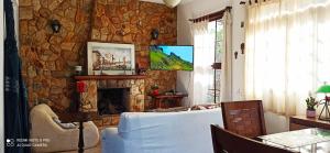uma sala de estar com uma parede de pedra e uma lareira em Aventura & Tranquilidade em Secretário pertinho de Itaipava - Trilhas Mountain Bike - Passeios de Quadricilo e Cavalo - Cachoeira em Petrópolis