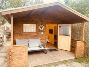 un grand hangar en bois avec un canapé sur une terrasse dans l'établissement Chatky Daniel-Mikulov, a private campsite just for you, à Mikulov