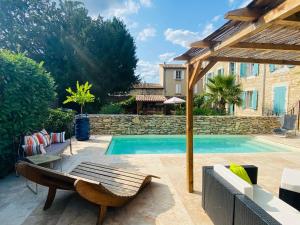 - une piscine avec un banc à côté d'une maison dans l'établissement Aux Berges du Libre, à Félines-Termenès