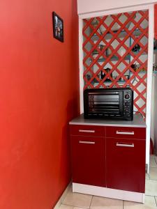 a microwave on a counter in a kitchen with a wine rack at Appartement de 2 chambres avec jardin clos et wifi a Basse Terre in Basse-Terre