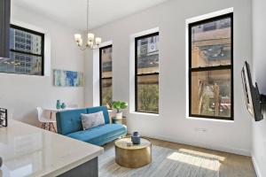 a living room with a blue couch and some windows at Calm & Minimalist 1BR Apartment - Lake 204 in Chicago