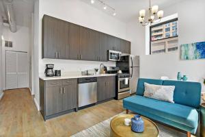 a kitchen with a blue couch and a table at Calm & Minimalist 1BR Apartment - Lake 204 in Chicago