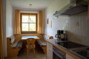 eine Küche mit einem kleinen Tisch, einem Tisch und Stühlen in der Unterkunft Wiesgut in Völlan