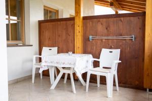 einen weißen Tisch und vier weiße Stühle und einen Holzzaun in der Unterkunft Wiesgut in Völlan