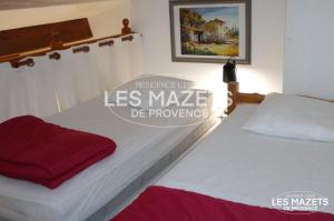 two beds in a room with the words las maske de provence at Mazet l’Olivier in Saint-Martin-de-Brômes +55 photos