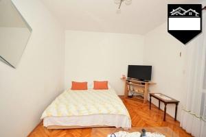 a bedroom with a bed with two orange pillows on it at Apartment Jelka in Herceg-Novi