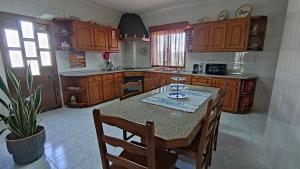 a kitchen with wooden cabinets and a table with chairs at Casa Araújo in Mós