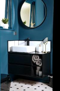 a blue bathroom with a sink and a mirror at HOH - Hazel's Boudoir in Matamata
