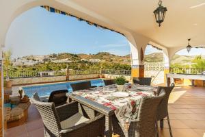 a patio with a table and chairs and a pool at Villa Triana in Nerja