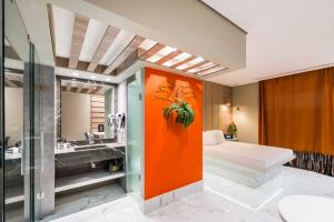 un bagno con parete arancione, lavandino e vasca di Motel Mood a San Paolo