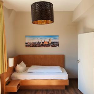 a bedroom with a bed and a chandelier at Hotel Friedensbruecke in Greiz