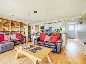 a living room with couches and a table at Solway Cottage in Bowness-on-Solway