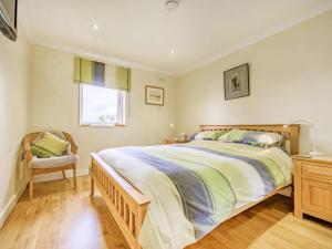 a bedroom with a large bed and a chair at Solway Cottage in Bowness-on-Solway