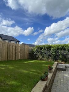 un cortile con recinzione in legno e cortile verde di Copperview Apartment a Newcastle