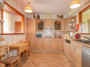 uma cozinha com armários de madeira, uma mesa e uma sala de jantar em Braehead Croft em Portessie