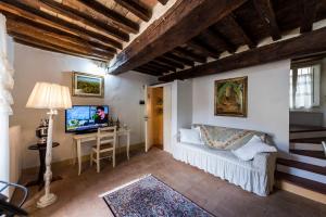 un soggiorno con divano e TV di Gente Vibia bed and breakfast a Monte Castello di Vibio