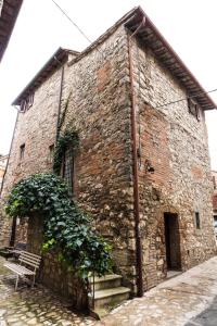 un edificio di mattoni con una panca di fronte di Gente Vibia bed and breakfast a Monte Castello di Vibio