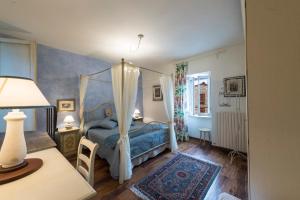1 dormitorio con cama con dosel y mesa en Gente Vibia bed and breakfast, en Monte Castello di Vibio