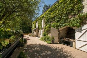 pokryty bluszczem budynek z ścieżką obok domu w obiekcie Moulin de la Follaine Gîte Le logis du meunier w mieście Azay-sur-Indre