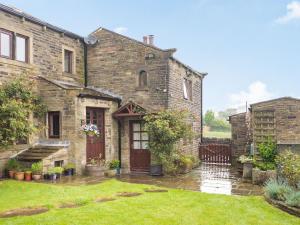 an old stone house with a garden in the yard at Green Clough Farm in Bradford