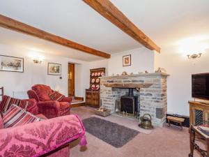 a living room with a fireplace and a tv at Green Clough Farm in Bradford