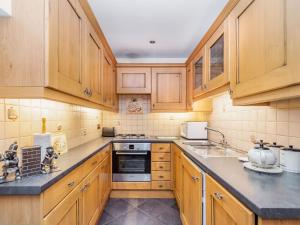 Una cocina con gabinetes de madera y un horno de estufa. en Green Clough Farm, en Bradford
