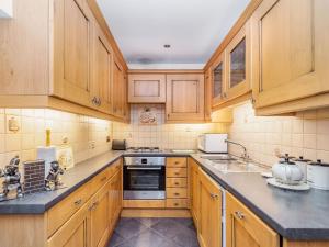 a kitchen with wooden cabinets and a stove top oven at Green Clough Farm in Bradford